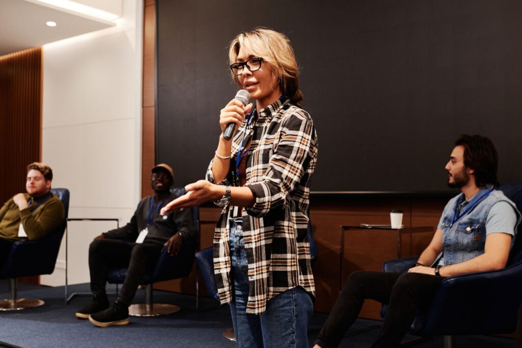 A person speaking on a mic at a public forum