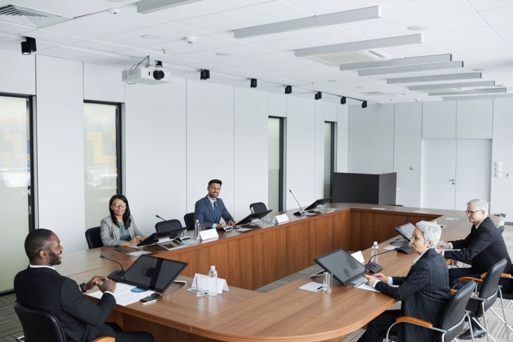 A diverse range of policymakers and stakeholders reviewing public comment analysis at a roundtable