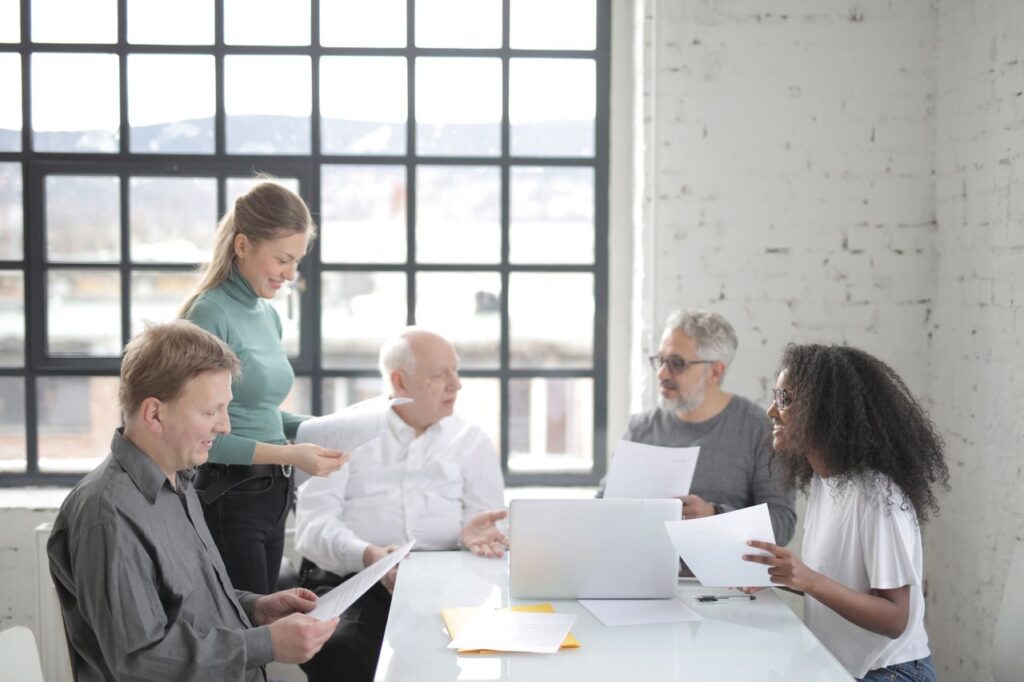 A diverse team of municipal employees in an office overlooking their city, planning local government communication strategy